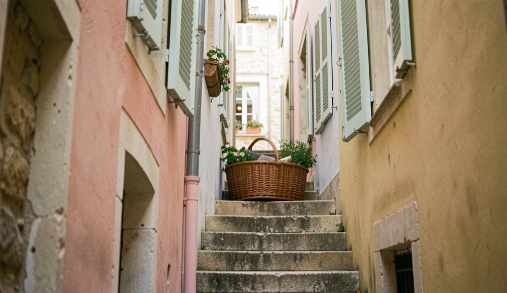 Escalier du Panier entre façades pastel et volets entrouverts
